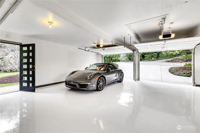 Bright extra-deep two-car attached garage with newly installed epoxy floor and utility sink