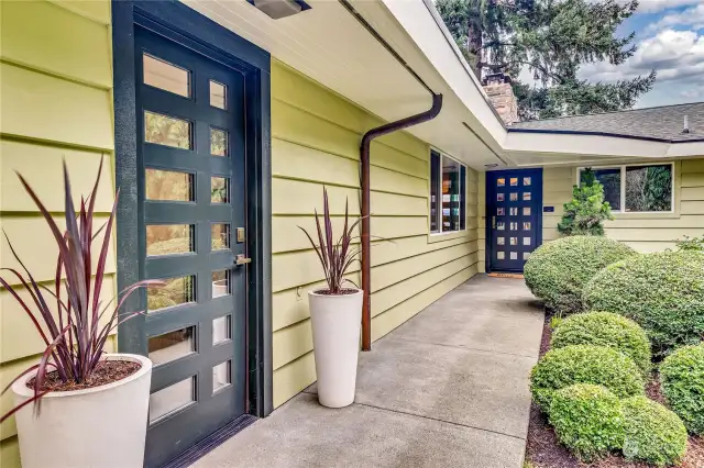 Easy-care landscape lovingly curated with a front lawn encircled by mature heirloom rhododendrons, Japanese maples, dogwoods, and magnolias