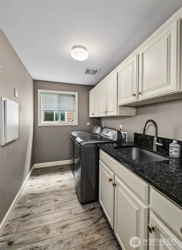 Laundry room off the kitchen is a nice touch in a condo.  Offers side by side space, laundry sink and many cabinets for storage.