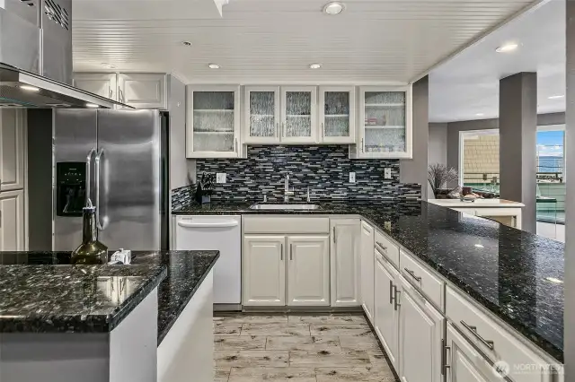 Many cabinets and countertops available in this large kitchen with island and eating bar.
