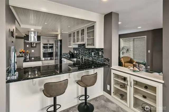 Kitchen looking from dining room space into the open eating bar.  Nice built-in glass cabinet for your glassware next to eating bar.