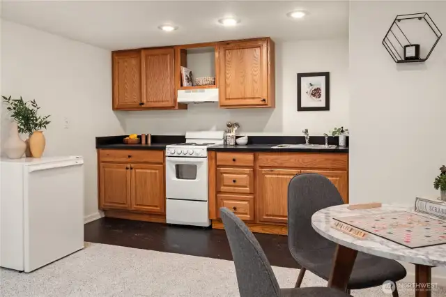 A second full kitchen includes a sink, stove, cabinets and a fridge.