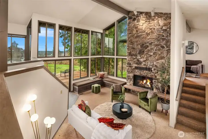 View from the main entry overlooking the living room, featuring a double-sided stone fireplace shared with the bonus room above.