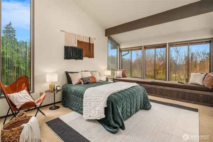 Primary bedroom offers vaulted ceilings, generous space, and beautiful views of the Sound.