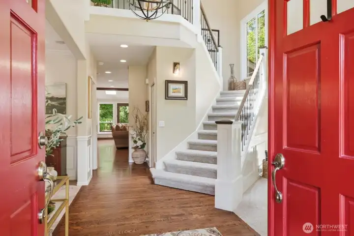 The welcoming entry opens to a dramatic two-story foyer accented by elegant wainscoting, soaring ceilings.