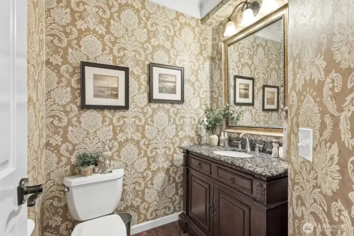 A beautifully updated guest powder room is located off the foyer and showcases designer finishes, including furniture-style vanity, elegant lighting, and sophisticated details that reflect the quality found throughout the home.