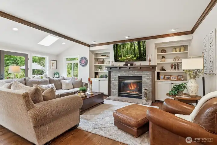 The family room features a dramatic stone-surround fireplace flanked by built-ins, creating a cozy focal point for relaxation and entertaining.