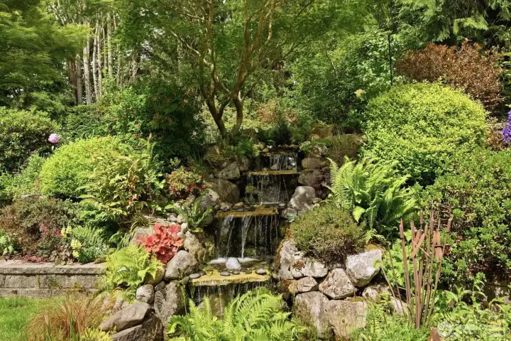2 tier waterfall amidst flowering perennials.