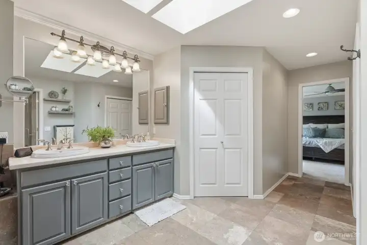 A granite-topped vanity provides storage and workspace, while two walk-in closets offer organization and convenience.