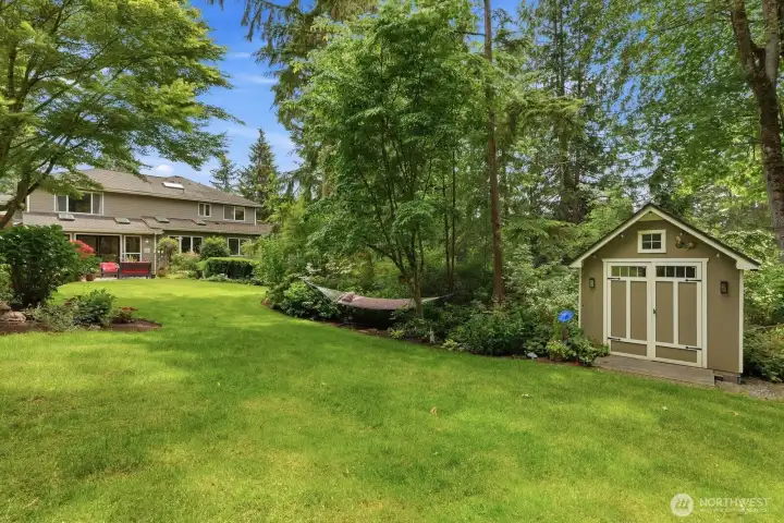 Carefully curated perennial gardens provide an ever-changing display of blooms throughout the seasons. On the west side of the yard is a wooded area with lined with hostas, hydrangeas and many other shade loving plants and the garden shed.