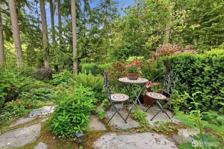 Second tier of the backyard is planted with perennials planted underneath the trees. It’s here you’ll find a secret cottage garden and a path that takes you to a colorful seating area.