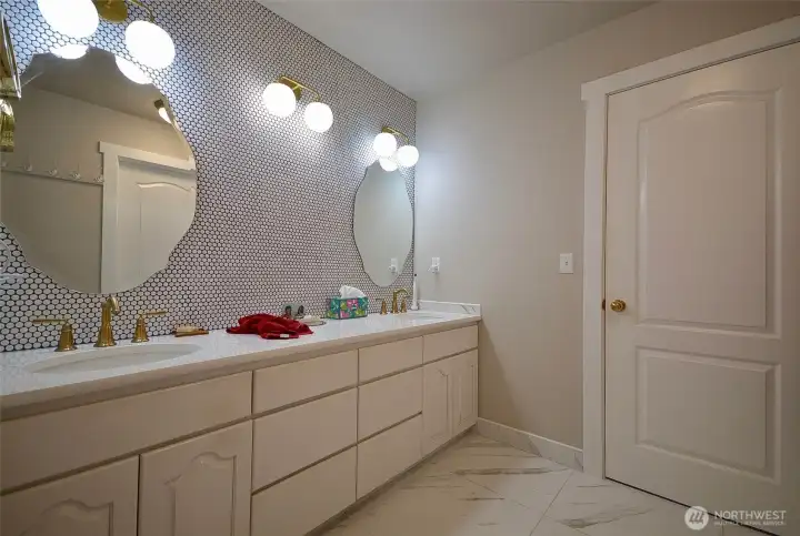 The exquisite main bath has a wall to wall vainity system topped with quartz countertops. A fully tiled wall serves as the backsplash and makes a statement of quiet elegance. The exquisite main bath has a wall to wall vainity system topped with quartz countertops. A fully tiled wall serves as the backsplash and makes a statement of quiet elegance.