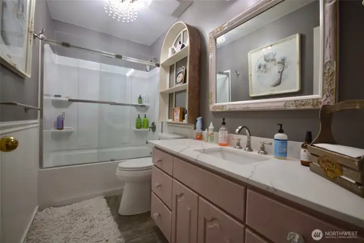 Bath #2 was recently renovated. It is equipped with a tub and showeer combo. The flooring is porcelain tile and the large countertop is quartz with an undermount sink. The bath serves the bedrooms on the left side of the home as well as guests. Bath #2 was recently renovated. It is equipped with a tub and showeer combo. The flooring is porcelain tile and the large countertop is quartz with an undermount sink. The bath serves the bedrooms on the left side of the home as well as guests.
