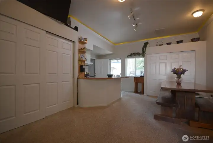 A view from the further end of the living room looking towards the entry. A bank of storage shelves on the left provides lots of space. A view from the further end of the living room looking towards the entry. A bank of storage shelves on the left provides lots of space.