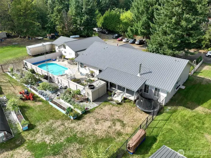 An aerial view of the main house, the covered veranda in the back and the swimming pool area. Some of the 21 raised beds show in this photo. They are equipped w automatic drip irrigation system. All the soil in the raised beds is organic...no pesticides ever used. If you don't have a leaning towards gardening, the 648 sq ft greenhouse and the raised beds could be rented out to a gardener....or any producer selling at the farmers market. An aerial view of the main house, the covered veranda in the back and the swimming pool area. Some of the 21 raised beds show in this photo. They are equipped w automatic drip irrigation system. All the soil in the raised beds is organic...no pesticides ever used. If you don't have a leaning towards gardening, the 648 sq ft greenhouse and the raised beds could be rented out to a gardener....or any producer selling at the farmers market.