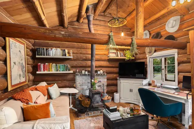Rustic inviting cabin features a freestanding stove and a fun loft.