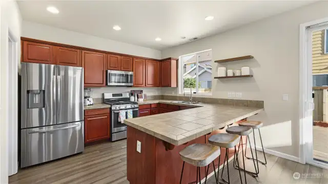 The kitchen shines with warm cabinetry, stainless steel appliances & plenty of counter space.