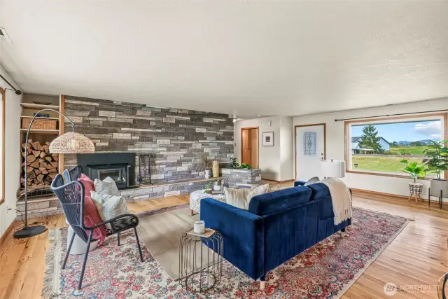 Gorgeous rock wall flanks great room - features newer wood burning insert and wood storage as well as a built in planter...