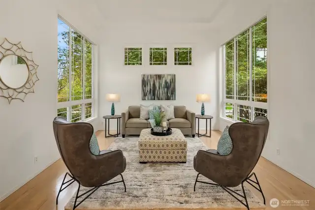 Formal living room has high ceilings and extra tall windows, bathing the room in light