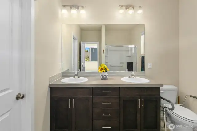Primary bath with dual vanity sinks, door to right is a large walk in closet, and there is also a nice sized walk in shower.