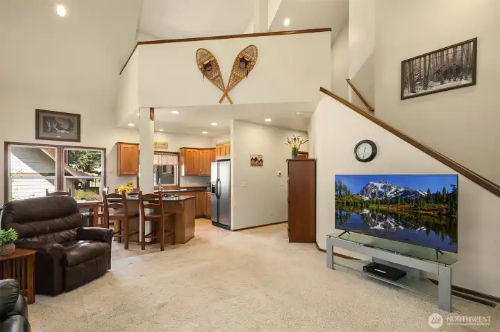 MOST FURNISHINGS STAY WITH HOME! This is the main living, dining and kitchen area. Stairs lead up to fabulous open loft (office space? guest quarters?) with extra sleeping room and 1/2 bath.