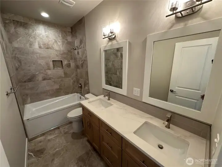 FOR ILLUSTRATION PURPOSES Guest bath with tile floors and shower surround and double vanity with solid quartz counter top. FOR ILLUSTRATION PURPOSES Guest bath with tile floors and shower surround and double vanity with solid quartz counter top.