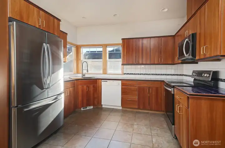 Cherry cabinets, tile counter tops and newer range, microwave & refrigerator.