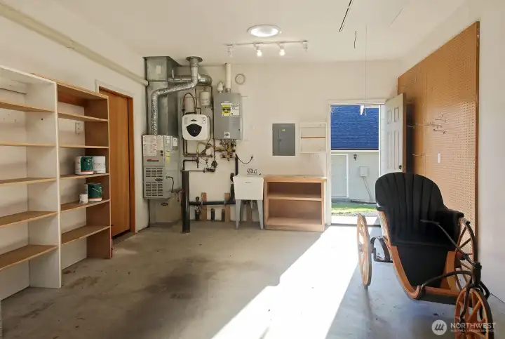 Tidy garage space with utility sink, peg board and shelving.