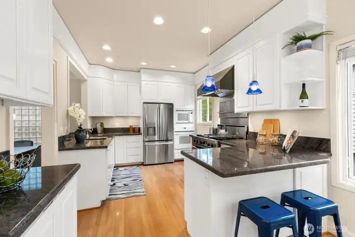 The large kitchen is a sleek culinary haven with black granite countertops, gleaming stainless appliances, and generous prep space – ready for any meal, from morning coffee to gourmet dinner.