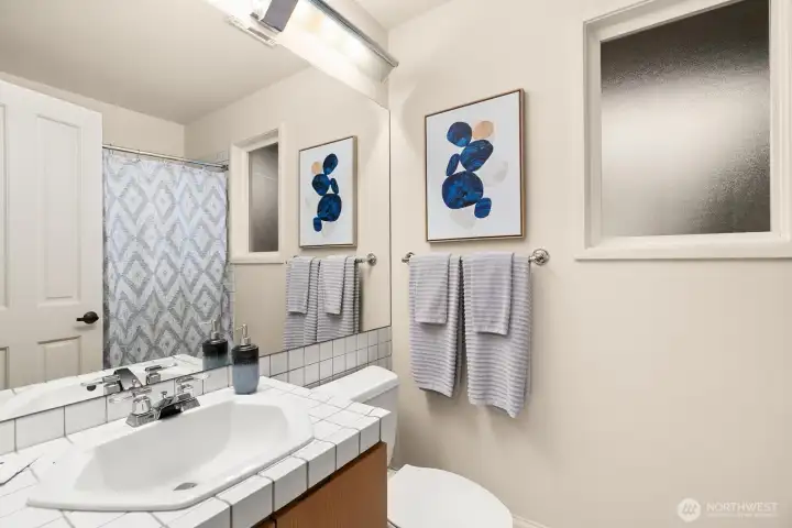 Full bath in lower level dedicated to thrid bedroom/study.