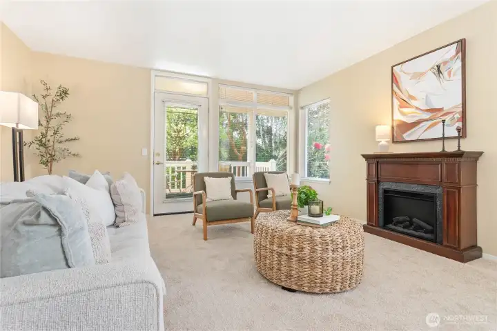 Spacious and cozy living space looks out to the deck with beautiful views of nature