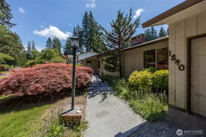 Ramp walkway to front entrance, surrounded by beautiful PNW plants.