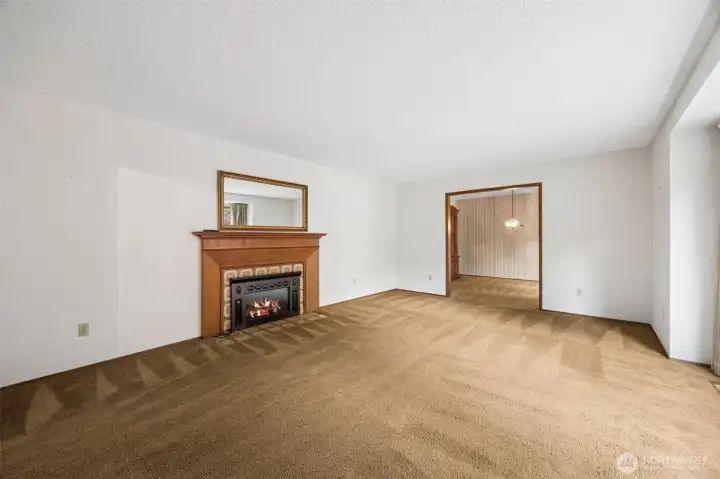 Expansive living room with a gas fireplace and easy flow into the formal dining room.