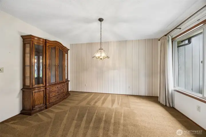Formal dining space also has a large window. Light abounds the living spaces in this fantastic home.