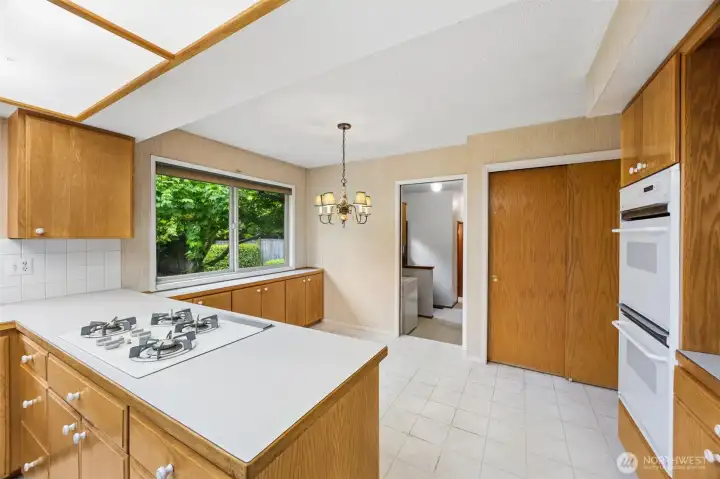 From the kitchen nook, go down a step to the utility room and much more. Storage closet shown here makes a great pantry!