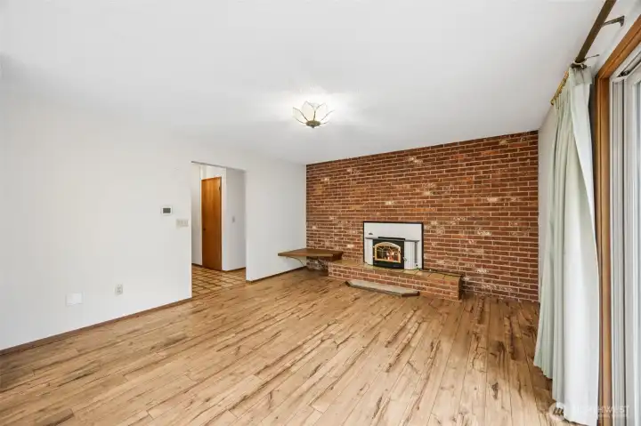 Second living space is open to the kitchen, has a fantastic brick wall with a fireplace.