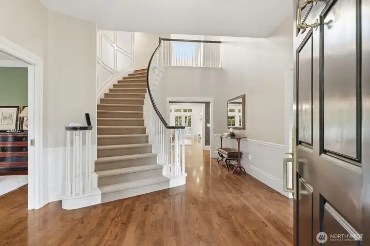 Classic Colonial architecture with formal rooms flanking the foyer with curved stairway with a wall of elegant shadow box moldings. Classic Colonial architecture with formal rooms flanking the foyer with curved stairway with a wall of elegant shadow box moldings.