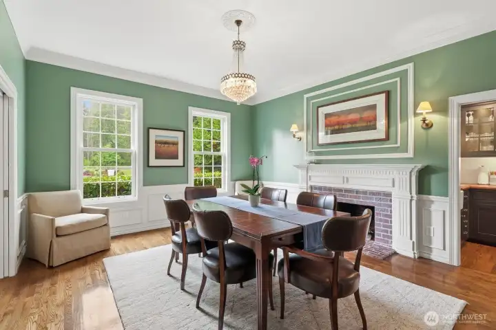 The formal dining room with wainscoting, crown molding also with a brick surround wood burning fireplace and crystal chandelier. The formal dining room with wainscoting, crown molding also with a brick surround wood burning fireplace and crystal chandelier.
