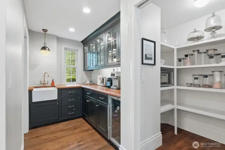 Beautifully appointed butler’s pantry with farm sink and beverage fridge. The large pantry area for the kitchen nearby. Beautifully appointed butler’s pantry with farm sink and beverage fridge. The large pantry area for the kitchen nearby.