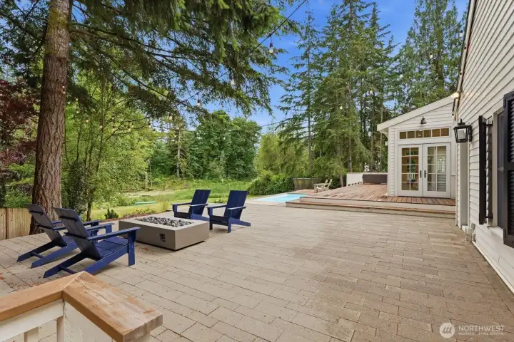 A stone patio with a fire table for year-round entertaining, a charming treehouse and a garden shed. A stone patio with a fire table for year-round entertaining, a charming treehouse and a garden shed.