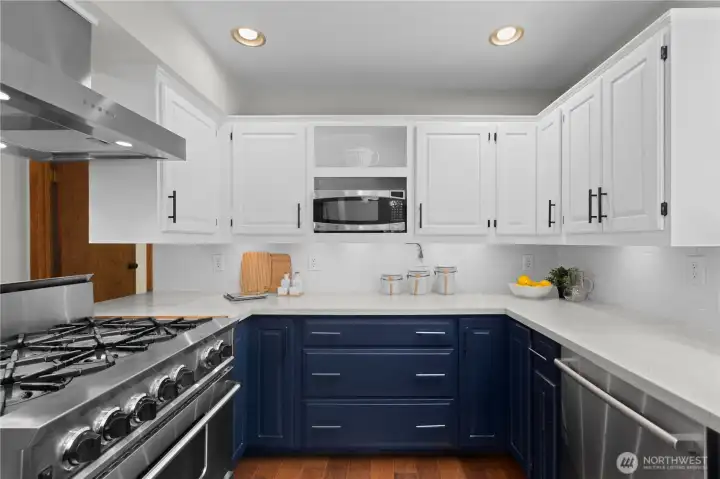 The updated kitchen features quartz countertops and stainless steel appliances.