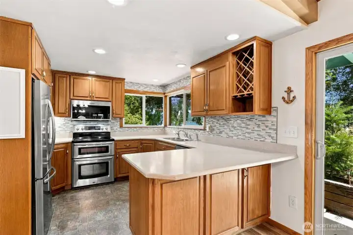 Well-appointed kitchen with warm wood cabinetry, stainless steel appliances, bar seating, and easy flow into the adjoining living spaces. Well-appointed kitchen with warm wood cabinetry, stainless steel appliances, bar seating, and easy flow into the adjoining living spaces.