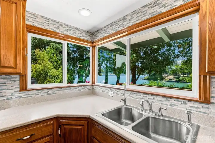 Corner kitchen windows bring in abundant natural light and frame private views of the water. Corner kitchen windows bring in abundant natural light and frame private views of the water.