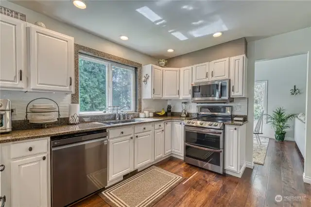 The open and user friendly kitchen has beautiful granite counters, Stainless steel appliances and lots of gorgeous cabinetry.