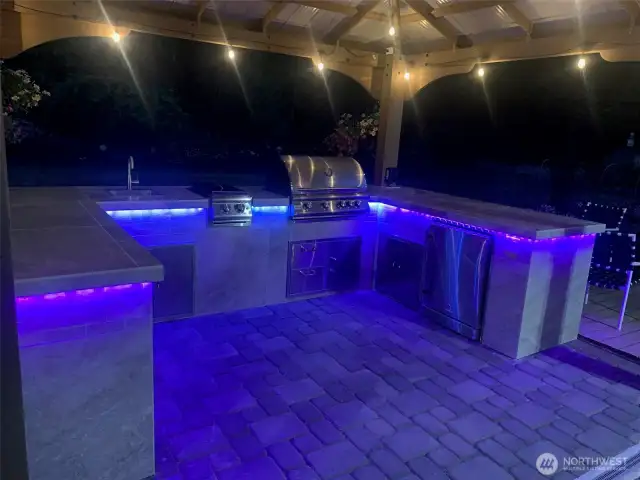 Lighted outdoor kitchen at night.