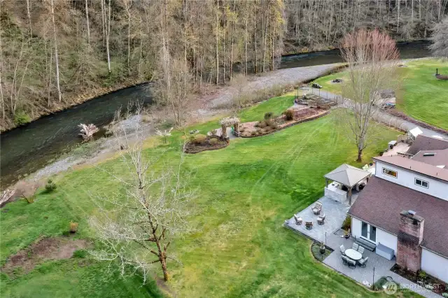 Aerial view of the back of the property and garden areas along the river.