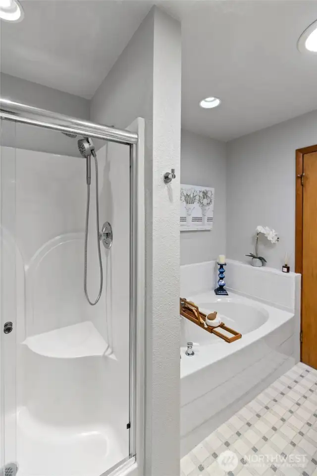 A walk-in shower with a seat in the hallway bath