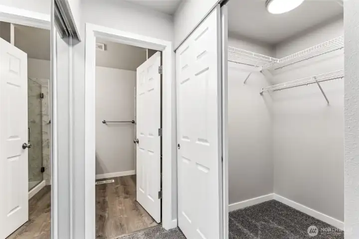 The primary bedroom has two closets, one to the left and a walk-in closet to the right.