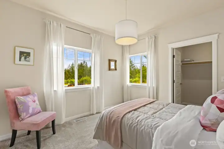 Main-level bedroom #3 boasts a generous walk-in closets and windows on two walls.