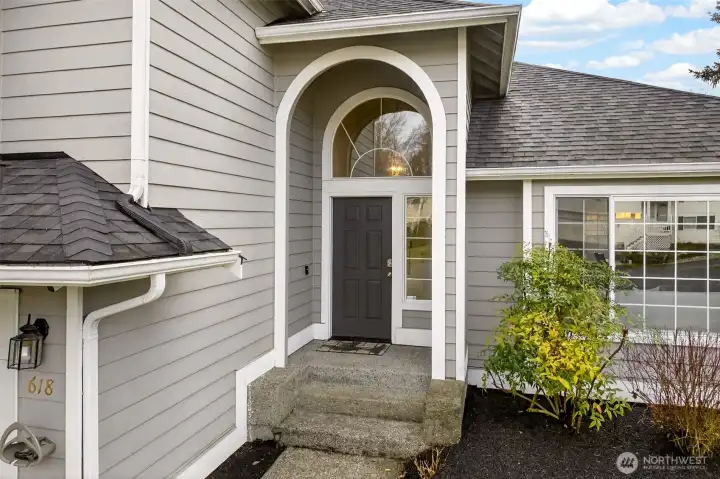 A covered, arched entry with a dramatic transom window adds character while keeping arrivals protected from the elements. The recessed front door creates a nice sense of privacy and a warm welcome for guests.